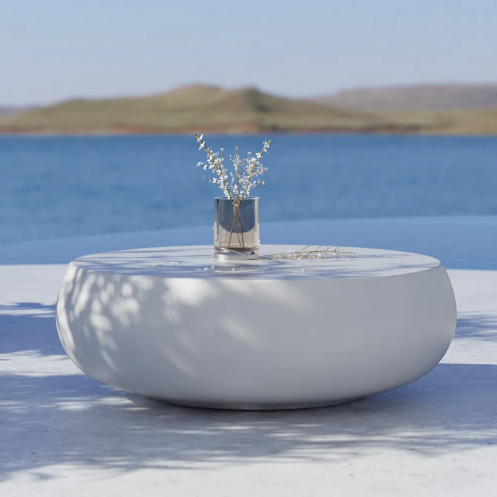 Detalhe aproximado da mesa de centro Ariel de exterior em branco, mostrando a superfície lisa e o volume arredondado.