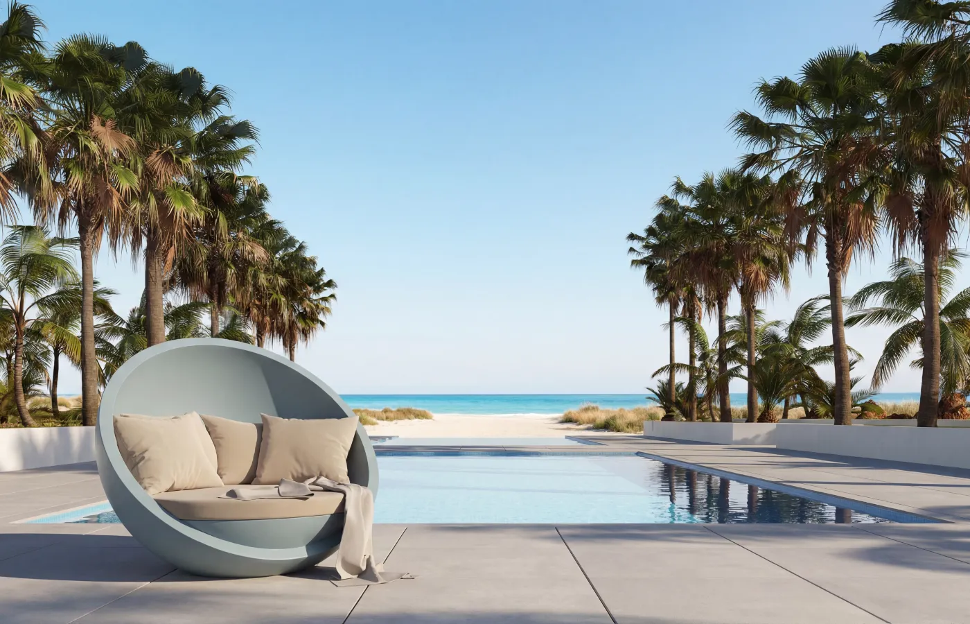 Bola outdoor sofa in light blue by a pool with sea view and palm trees, highlighting its circular shell and cushioned seat.