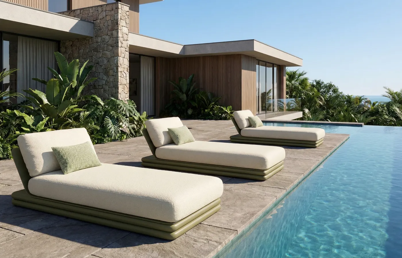 Capri chaise longues in green by a pool in a contemporary home with tropical garden.