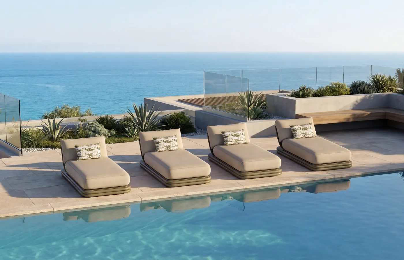 Set of green Capri chaise longues aligned by a pool overlooking the sea.