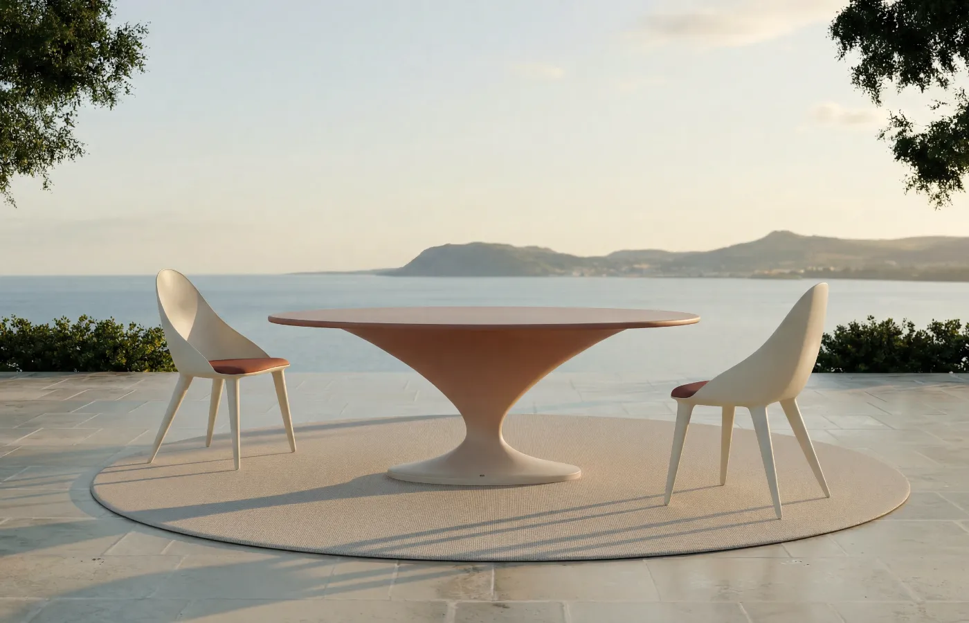 Mesa de jantar Charm com acabamento degradé branco e terracota num terraço junto ao mar, com tampo oval e base central curva entre duas cadeiras Mónaco.