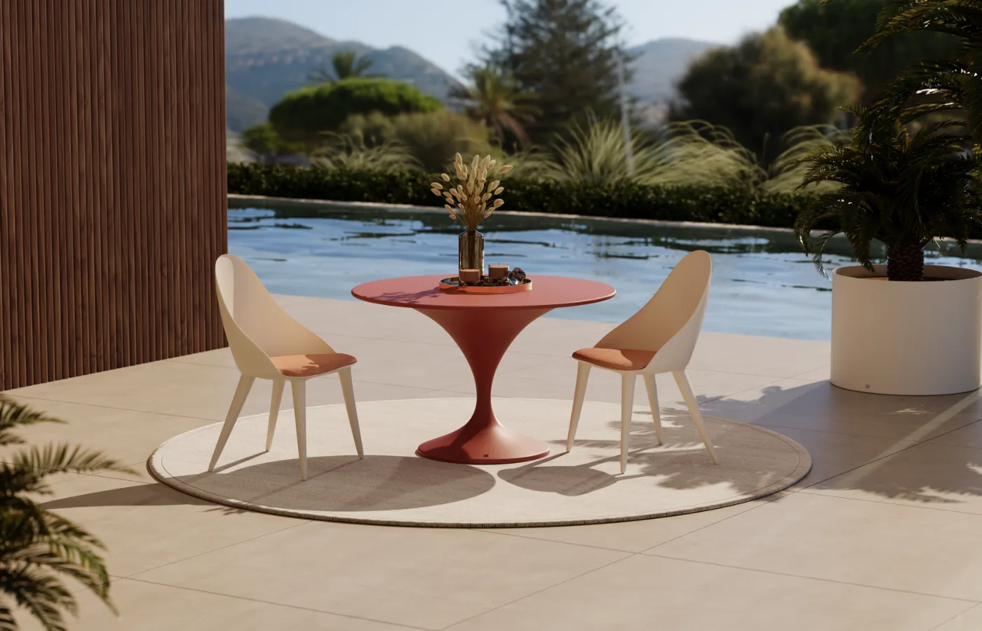 Charm dining table by the pool, with a round top and curved central base in terracota color, paired with two Mónaco chairs.