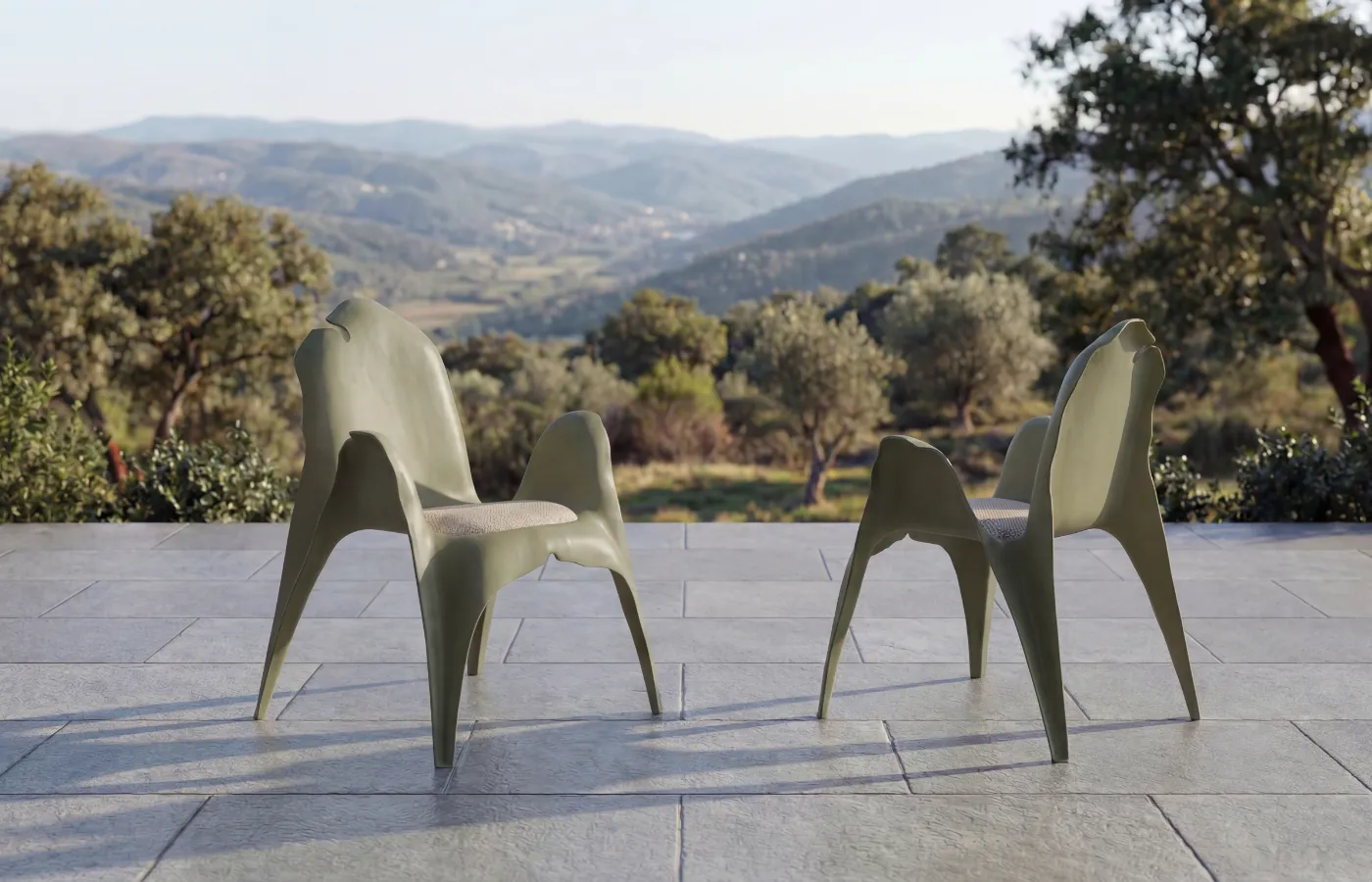 Duas cadeiras Cibelle em acabamento verde num terraço exterior, com vista de perfil que destaca as pernas afiladas.