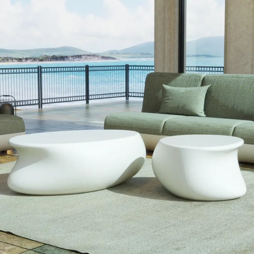 Detalhe do conjunto de mesas de apoio e centro Echo para exterior, mostrando os seus volumes curvos em branco.