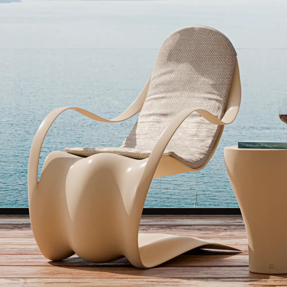 Detalhe da poltrona Flex em bege com almofada contínua, braços curvos abertos e base ondulada em ambiente exterior.