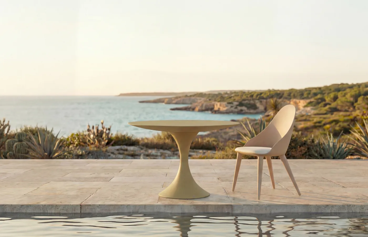 Mesa de jantar redonda Jade em verde-claro para exterior, ao lado de uma cadeira Mónaco, numa varanda junto à piscina com vista mar.