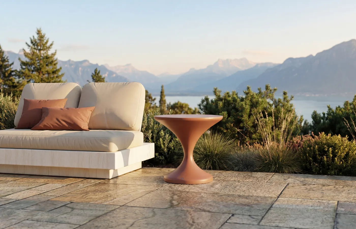Lya outdoor side table in a terracotta finish, placed beside a Nordic sofa on a terrace with a mountain view.
