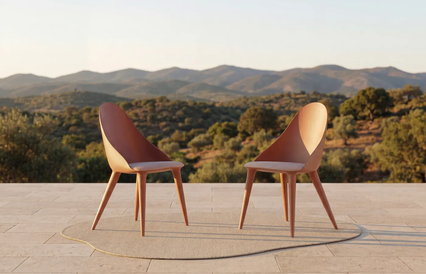 Two Mónaco chairs in red on an outdoor terrace, shown in profile, with curved backrests, cushioned seats and tapered legs