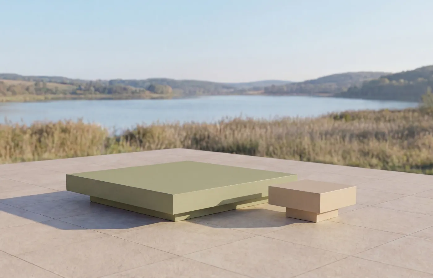 Conjunto de mesas de centro e apoio Nordic para exterior em verde e bege, colocado em terraço com vista para o lago.