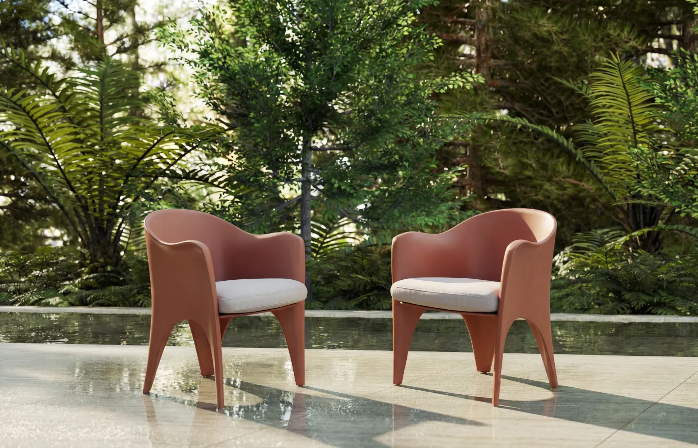 Two Oceano chairs in red on an outdoor terrace, with cushioned seats and an enveloping frame with soft lines.