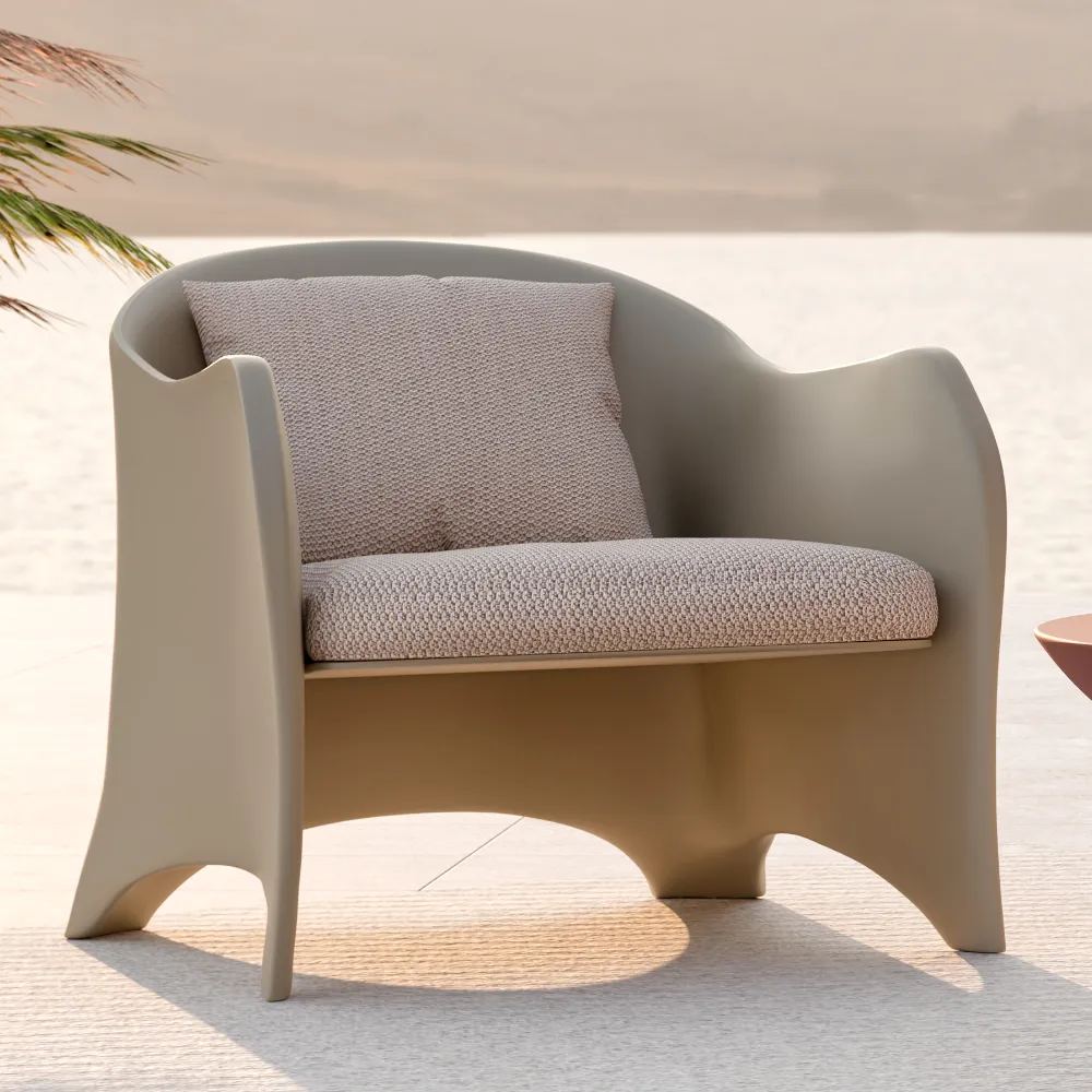 Detail of the Oceano armchair in beige with a continuous backrest, integrated arms and seat and back cushions in an outdoor setting.