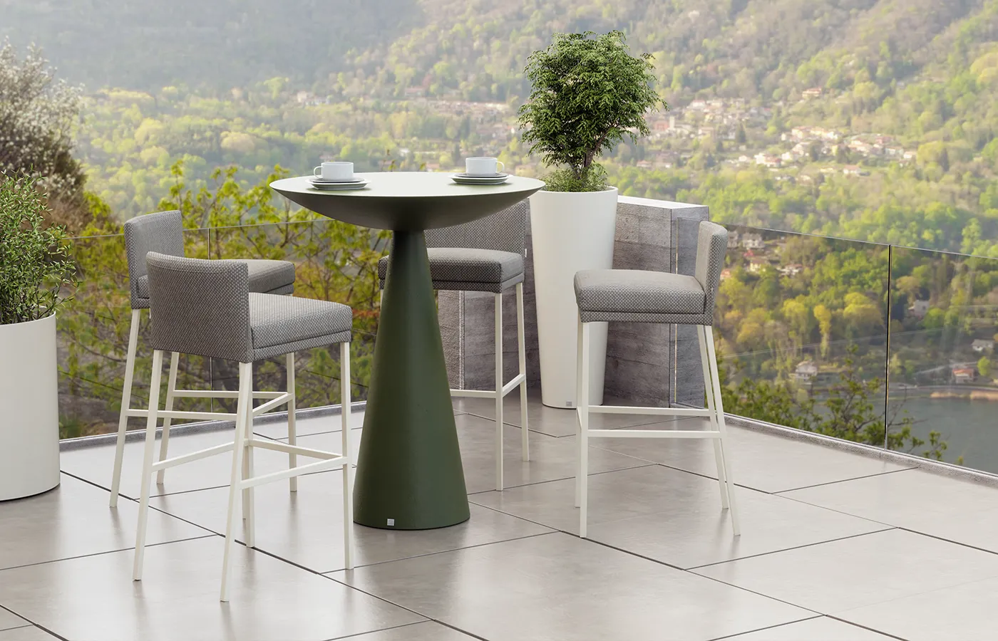 Oceano bar table in green on a balcony overlooking the river.
