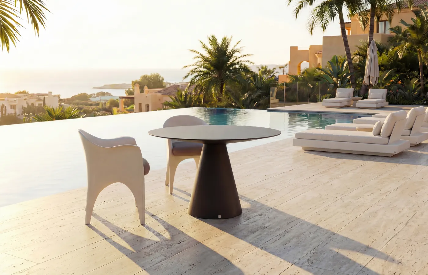 Oceano round outdoor dining table in brown, set between two Oceano chairs on a poolside terrace.