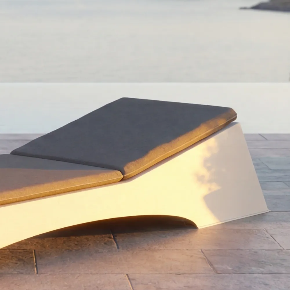 Close-up of the Quadra chaise longue showing the continuous cushion and the visible arched cut-out in the base.