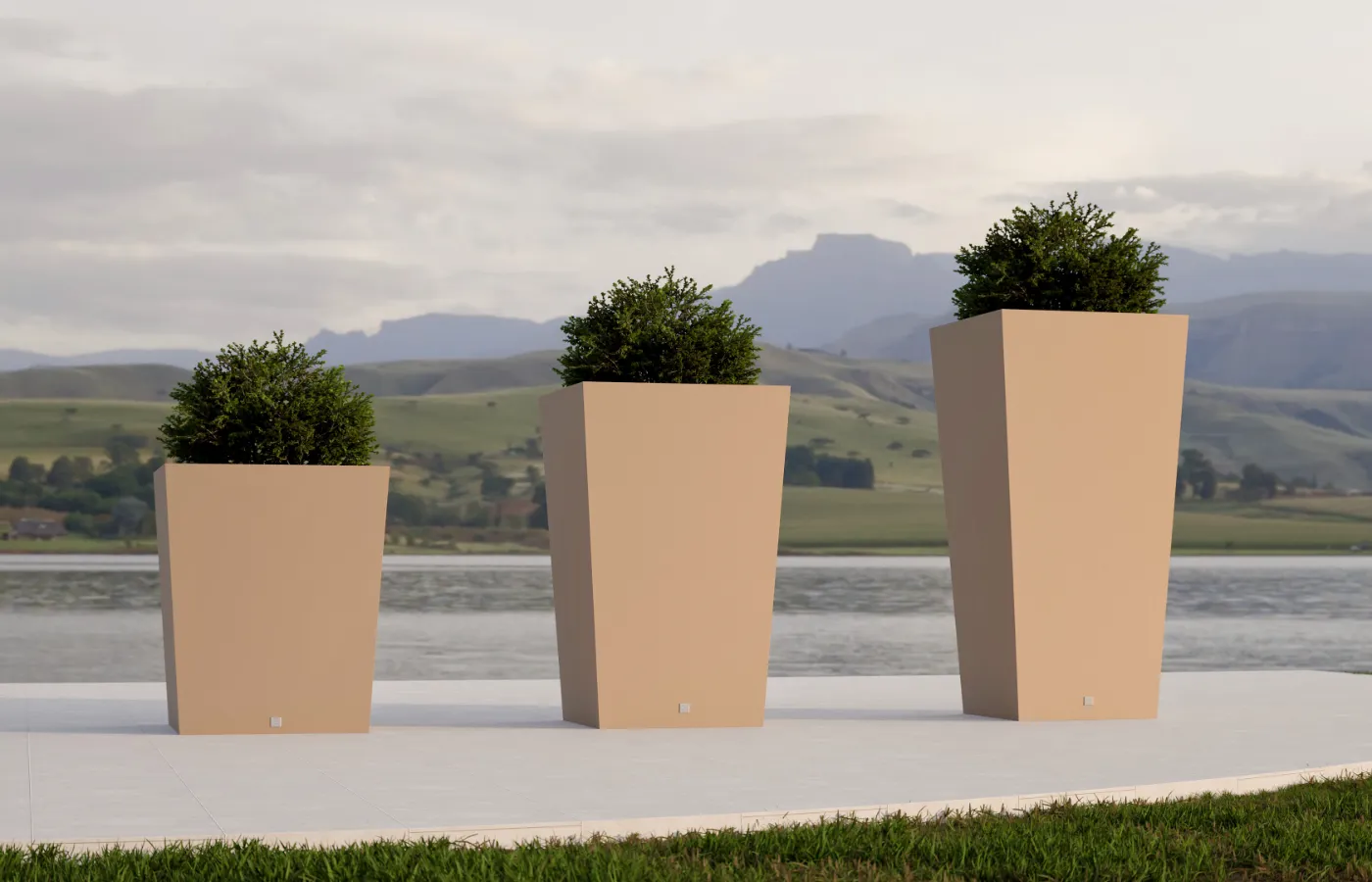 Quadra small planters in different heights in beige on a terrace overlooking a lake and hills, with angular shapes and dense shrubs.