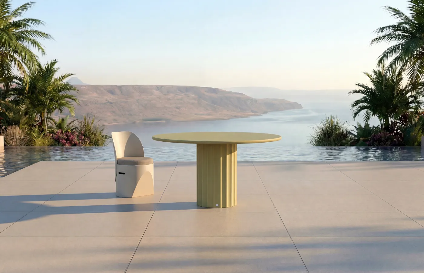 Roma round outdoor dining table in soft green, with a fluted base, beside Cloe chair by the pool.
