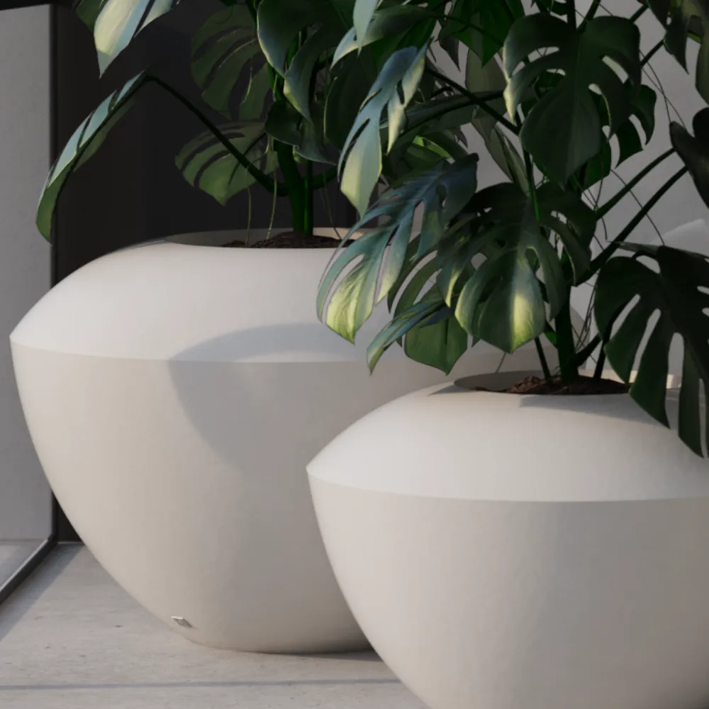 Close-up of Spin white small planters with rounded shapes and tropical plants in an outdoor setting.