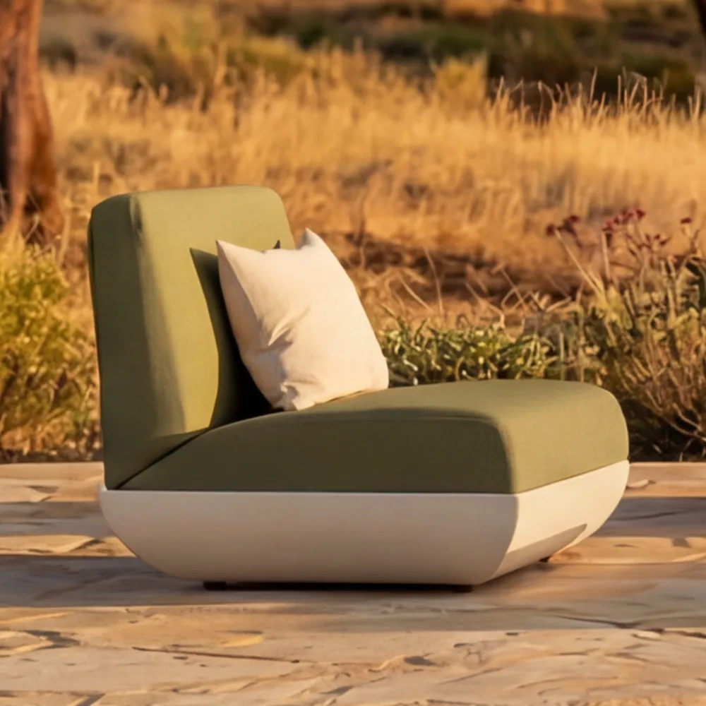 Detalhe do sofá Victoria com base arredondada, assento verde estofado e encosto curvo com almofada solta.