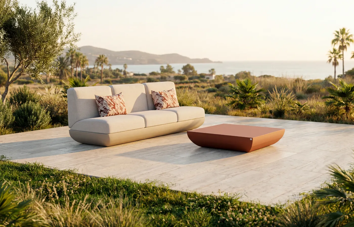 Mesa de centro Victoria para exterior em acabamento terracota, colocada diante de um sofá Victoria em jardim com vista para o mar.