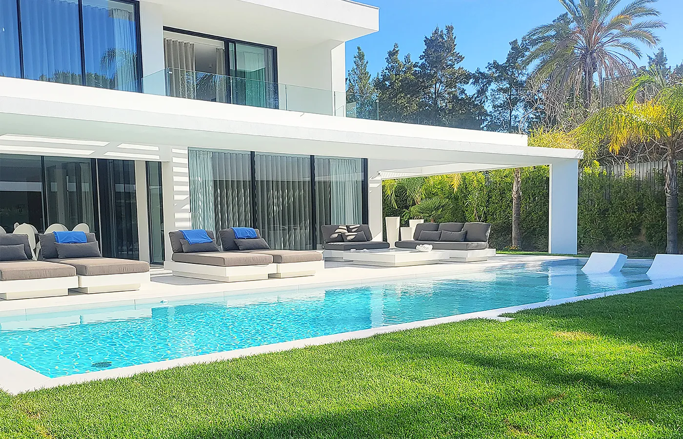 Chaise longues de design moderno Nordic junto a piscina em moradia de luxo contemporânea