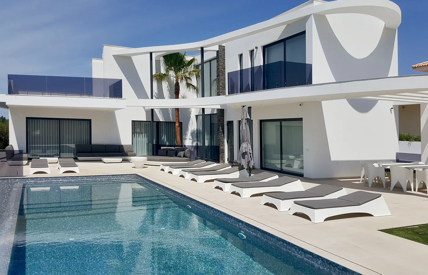 Chaise longues de design moderno Quadra junto a piscina em moradia de luxo contemporânea