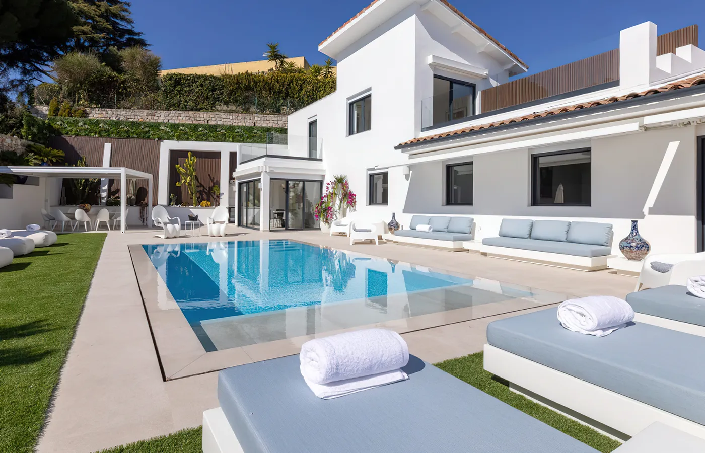 Sofás e chaise longues de design moderno Nordic junto a piscina em moradia de luxo contemporânea