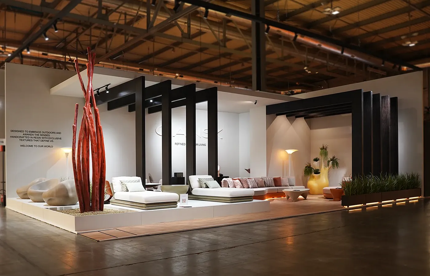 Stand da GANSK na Salone del Mobile Milano 2026 com mobiliário de exterior de luxo, sofás outdoor contemporâneos, daybeds e iluminação moderna.