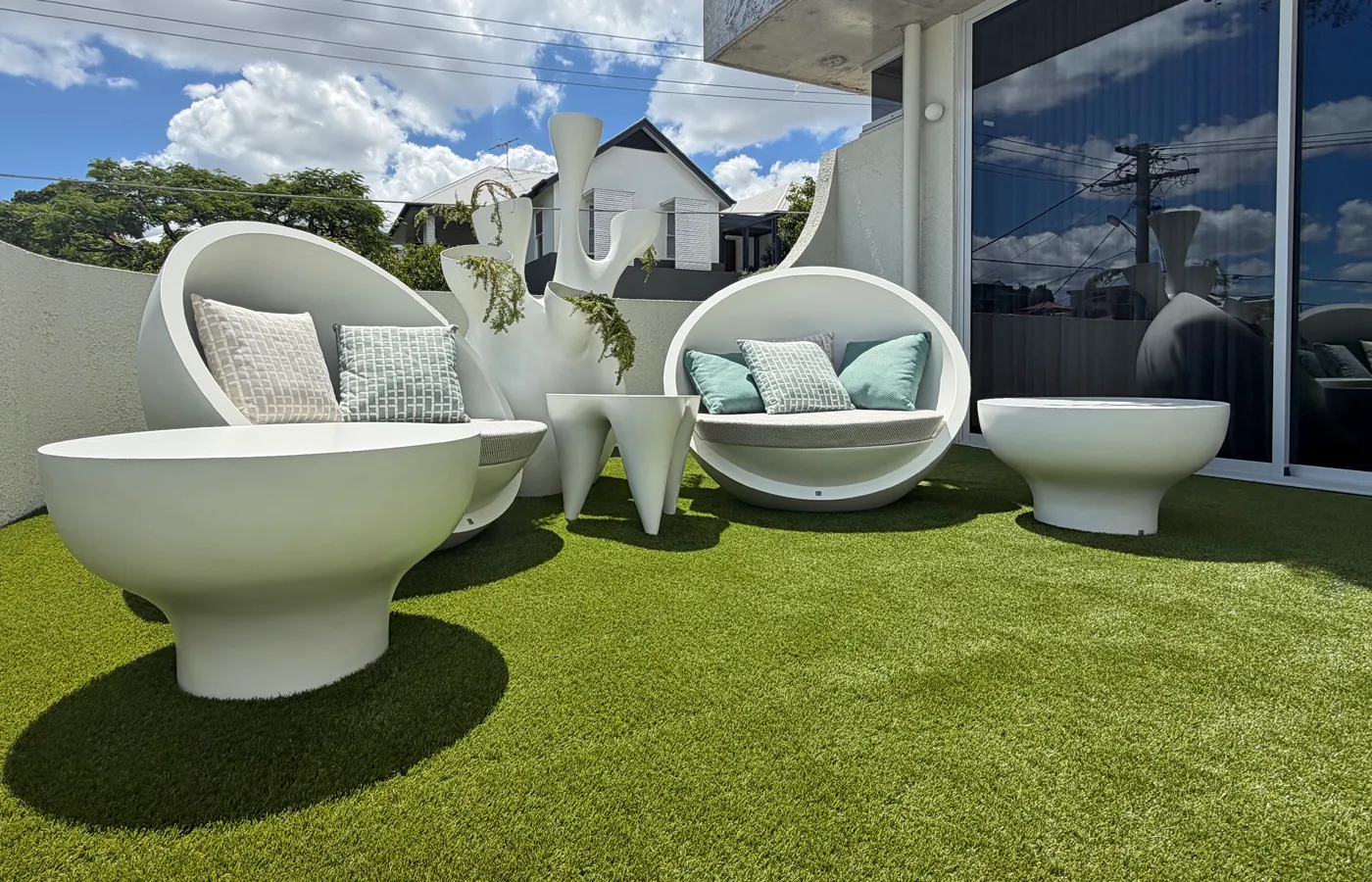 Zona de estar exterior com sofás Bola, mesas Bloom, mesa Ivory e vaso Coral