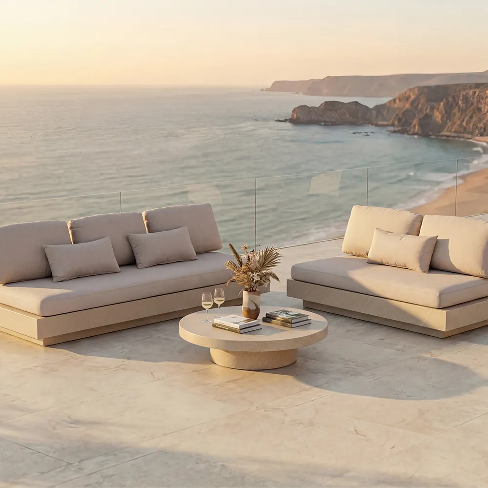 Outdoor terrace by the sea featuring a set of beige Nordic sofas and a round coffee table